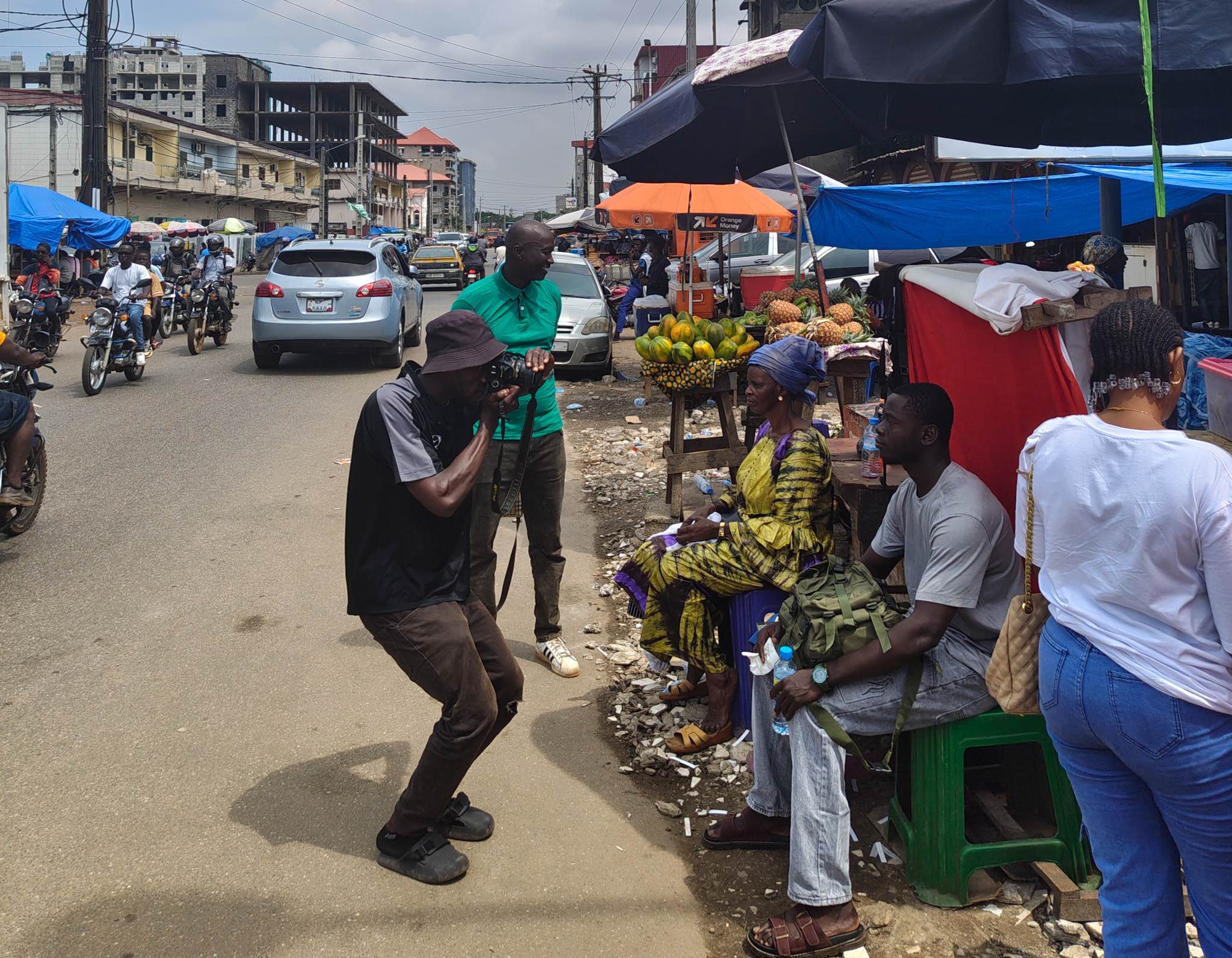 People getting their passport photo taken on the side of the road