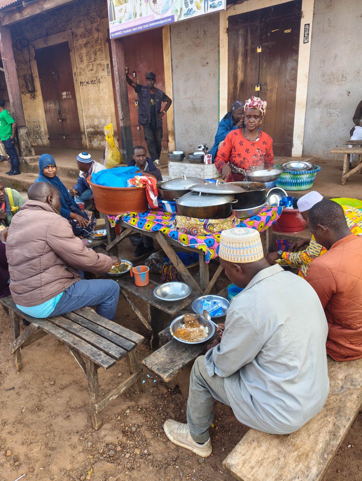 Street food in Guinea, this lady was selling domoda, a dish made from a base of peanut stew, tomatoes, and some meat of unknown origin served over rice