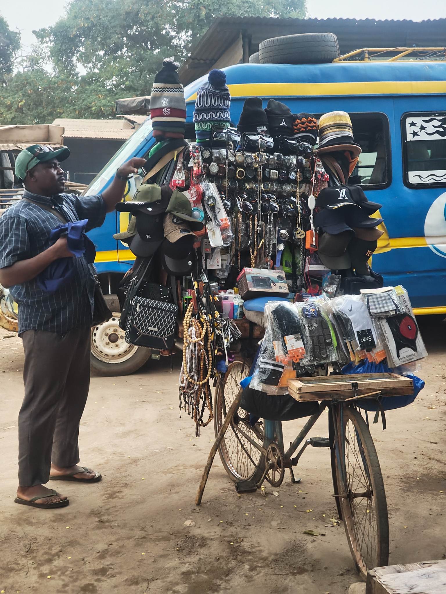A man selling all sorts of wares from his bicycle in Kong, Ivory Coast
