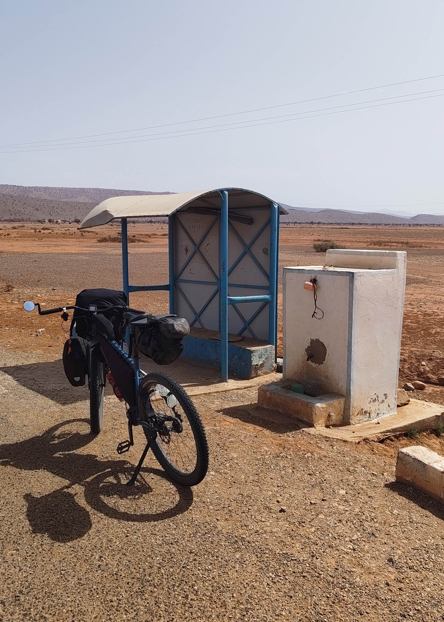 A godsend in the desert: shelter from the sun with a bench, and a tap to refill my water bottles